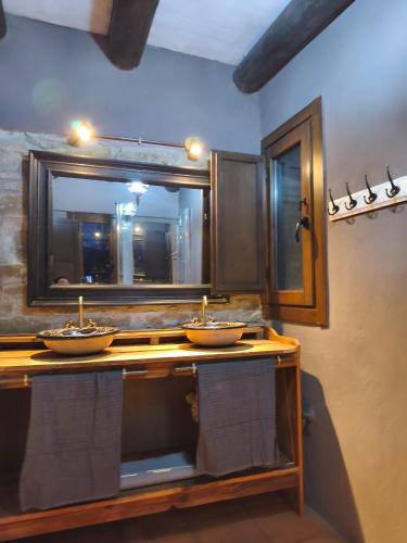 a bathroom with two sinks and a large mirror at A Boira Rural in Osia