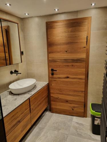 a bathroom with a sink and a wooden door at Ferienwohnung Unterdürmoos in Annaberg im Lammertal