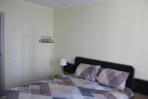 a bedroom with a bed and a lamp at Ezerkrasta Apartment in Liepāja