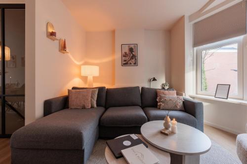 a living room with a couch and a table at Luxe appartement op toplocatie in centrum Rotterdam Stay&Rejoice in Rotterdam