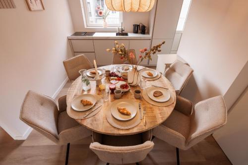 a dining room table with chairs and food on it at Luxe appartement op toplocatie in centrum Rotterdam Stay&Rejoice in Rotterdam