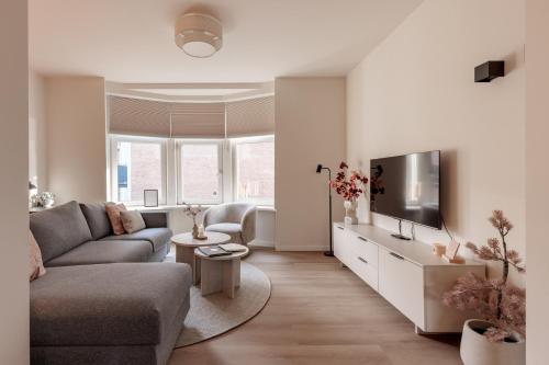 a living room with a couch and a tv at Luxe appartement op toplocatie in centrum Rotterdam Stay&Rejoice in Rotterdam