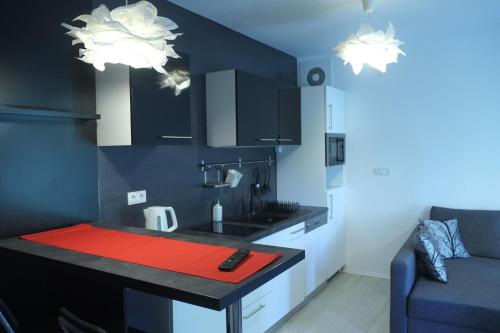 a kitchen with a red counter top in a room at Apartman Gala in Čakovec