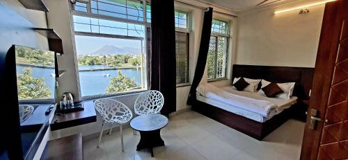 Antariksh - IN UDAIPUR في أودايبور: غرفة نوم بسرير وإطلالة على بحيرة