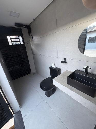 a bathroom with a black toilet and a sink at Espaço Atlântico in Goiânia