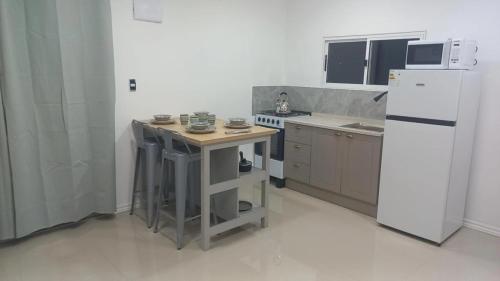 een kleine keuken met een witte koelkast en een tafel bij ChicPDD in Punta Del Diablo