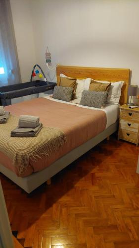 a bedroom with a large bed and a wooden floor at Guiki House in Lisbon