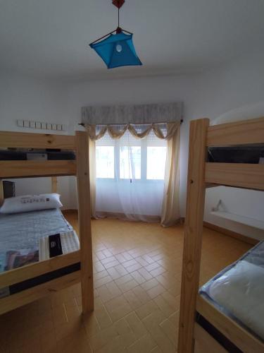 Un dormitorio con dos literas y una ventana. en Casa vacacional 6 personas, en Santa Teresita