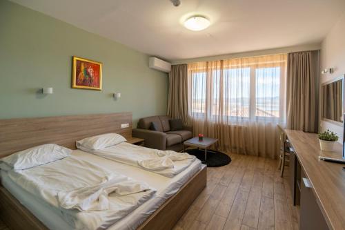 a hotel room with a bed and a chair at Hotel LaCasa Tsigov Chark in Batak