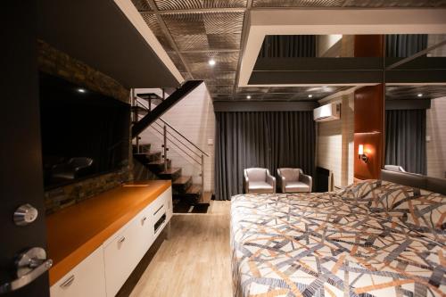 a bedroom with a bed and a tv and stairs at Hotel Le Chablis Cadillac in Montréal