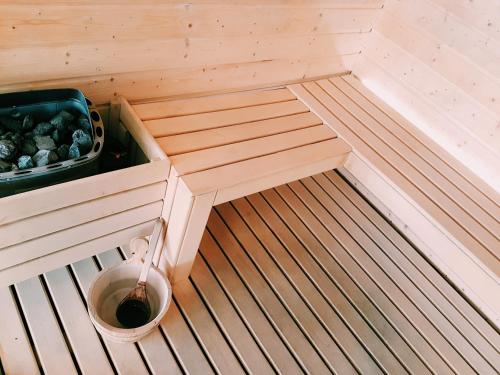 a small sauna with a bucket of water in it at Pedras do Mar Resort & Spa in Fenais da Luz