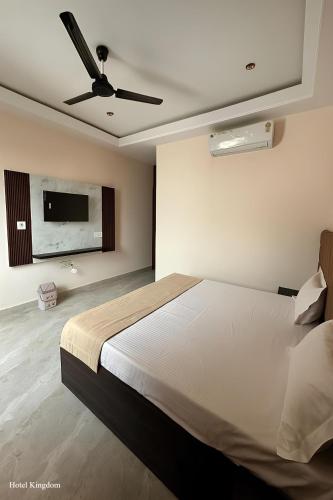 a bedroom with a large bed with a ceiling fan at Hotel Kingdom - 3 minutes From Golden Temple in Amritsar