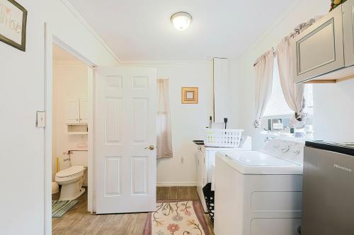 um banheiro branco com uma pia e um vaso sanitário em Little red house with vintage, retro feel to it! em Ocala