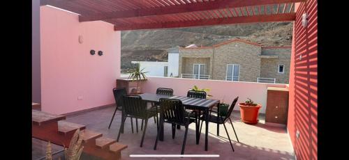 een terras met een tafel en stoelen op een balkon bij Ponta do Sol "A Boa Vida" in Ponta do Sol