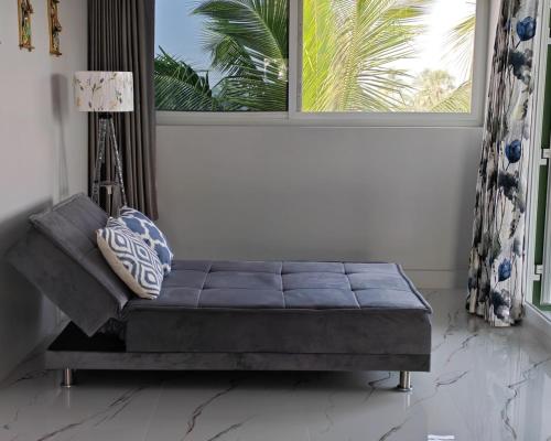 a couch sitting in a room with a window at Gangi Kota Penthouse in Kovvūr