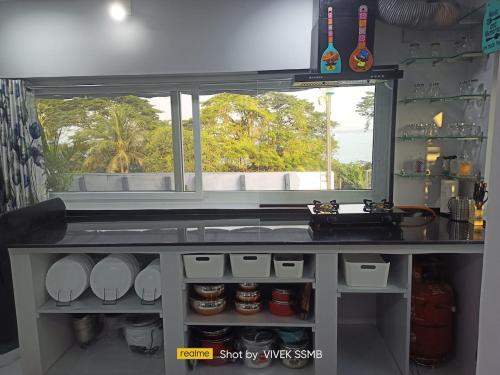 a kitchen with a counter with a sink and a window at Gangi Kota Penthouse in Kovvūr