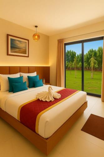a bedroom with a large bed with a large window at Road House Resort in Rāmeswaram