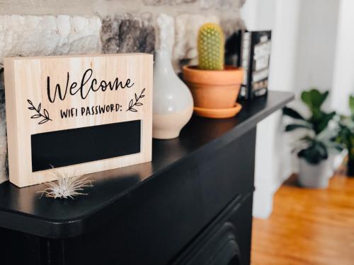 Una cómoda negra con un cartel de bienvenida. en Jungle House Luxury Homes - Columbus Downtown Short North - Steps to Convention Center & Nationwide Arena - Sleeps up to 11 - Free Parking - Over 5,800 Five Stars, en Columbus