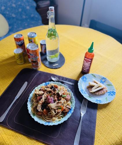 Una mesa con un plato de pasta y una botella de cerveza. en Studio Pool Drôme Provençale with Asian Meals Best Price, en Taulignan