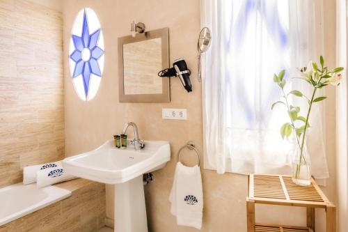 une salle de bain avec un lavabo et un miroir dans l'établissement Hotel Boutique Casa de Colón, à Séville