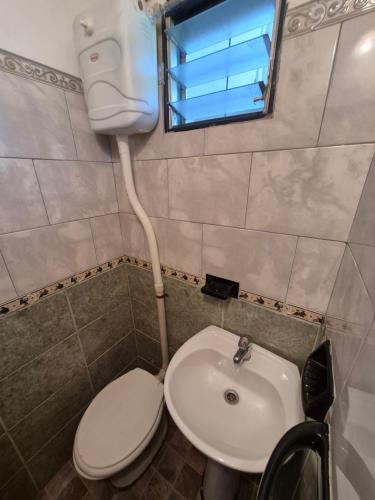 a bathroom with a toilet and a sink at Oasis in Villa Anizacate