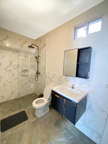 ein Badezimmer mit Toilette und Waschbecken in der Unterkunft Lakou Breda in Cap-Haïtien