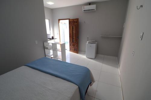 een kleine kamer met een bed en een koelkast bij Casa-Quarto Parnaíba in Parnaíba
