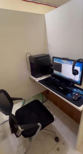a desk with a laptop computer and a chair at Upskill Coworking Space in Marilao
