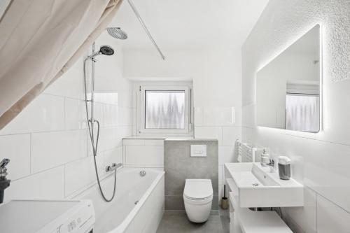 Un baño blanco con bañera, inodoro y lavabo. en Home Wutach Blue - Business Apartment near Swiss Border, en Lauchringen