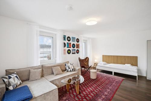 una sala de estar con un sofá y una cama en Home Wutach Blue - Business Apartment near Swiss Border, en Lauchringen