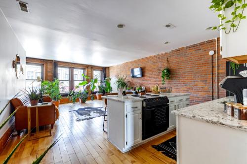 uma cozinha grande com uma parede de tijolos em Jungle House Luxury Homes - Columbus Downtown Short North - Walk to Convention Center & Nationwide Arena - Sleeps up to 10 - Free Parking - Over 5,800 Five Stars em Columbus