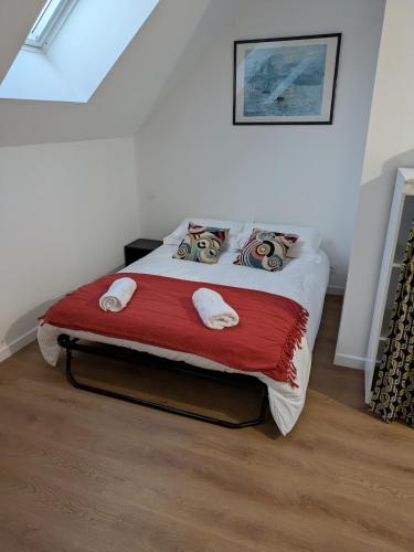 a bedroom with a bed with a red blanket at Aux Cormulets in La Baconnière