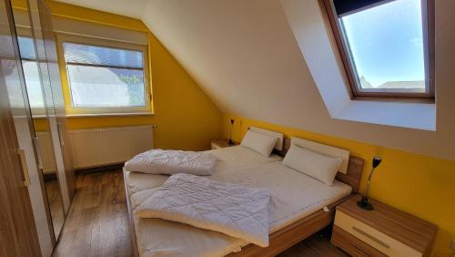 una piccola camera con due letti e due finestre di Ferienhaus Windland a Hof Dranske