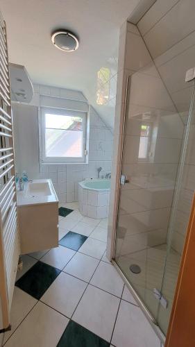 a bathroom with a shower and a sink and a tub at Ferienhaus Windland - mit Garten, Kamin und Sauna in Dranske