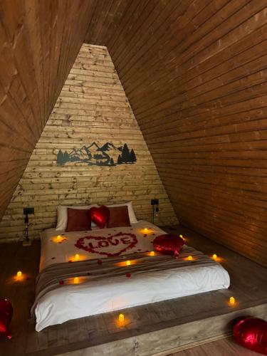 a bedroom with a bed with red pillows and lights at A-Wine Villas in Novaci