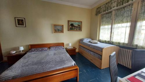 a bedroom with two beds and a window at Nonna Liliana in San Lorenzo al Mare