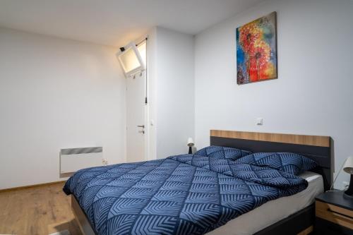 Un dormitorio con una cama con un edredón azul. en Apartment Znaor, en Kupres