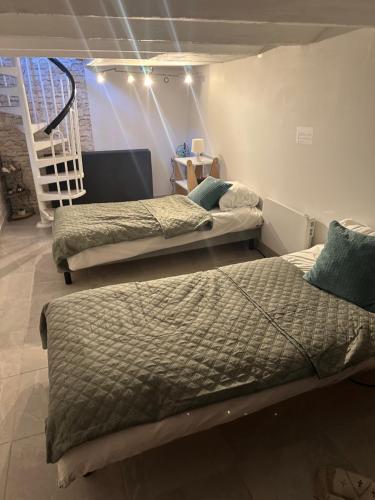 two beds sitting in a room with a staircase at Les 3 anges in Houilles