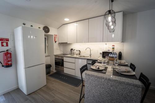 a kitchen with white cabinets and a white refrigerator at VanTop Xisto in Pampilhosa da Serra