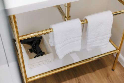 a glass shelf with a pair of shoes and towels at Whitlock16 - Luxe Aparthotel Montgomery Square Brussels in Brussels