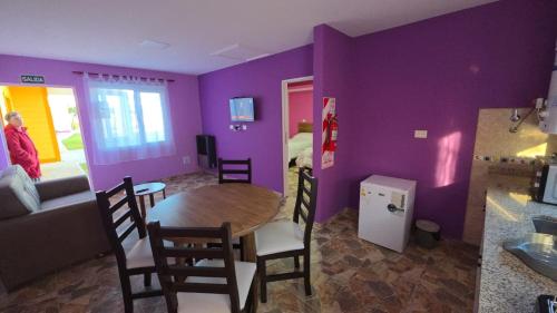 a dining room with purple walls and a table and chairs at 7 Rayos y el Sol in Río Gallegos