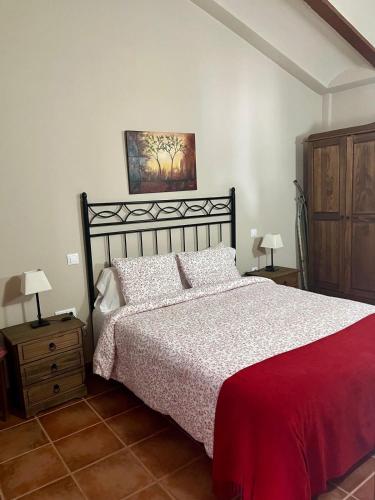 una camera con un letto e due lampade e un quadro di La Paidera de Cutanda 