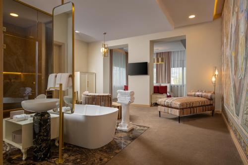 Un baño con bañera y un dormitorio. en Domeniile Martinutzi - Conac Rhédey, en Vintu De Jos