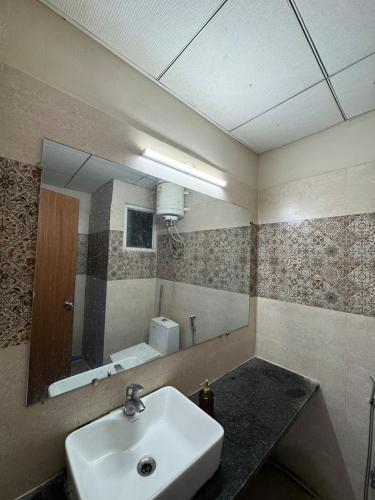 a bathroom with a sink and a mirror at Crown Suites in Greater Noida
