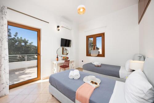 a bedroom with two beds and a balcony at Villa Aspa in Prinés