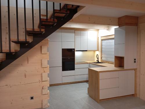 Zielone Wzgórze Sidzina في Sidzina: مطبخ بدولاب بيضاء ودرج
