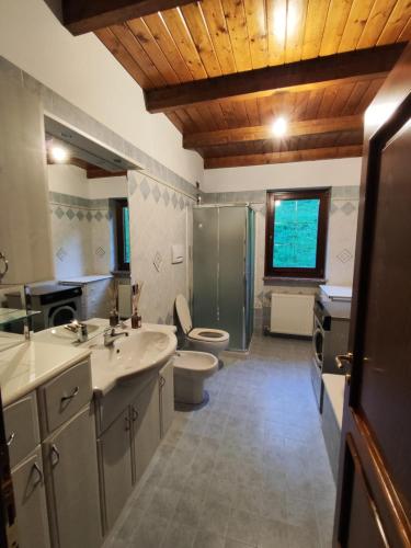 a bathroom with a toilet and a sink and a tub at Al Cacciatore in Gallio