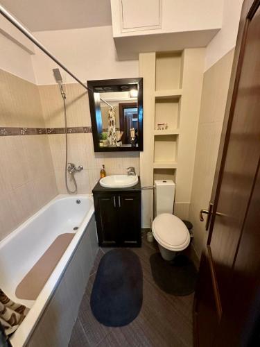 a bathroom with a tub and a toilet and a sink at 29 Nest Residence in Craiova