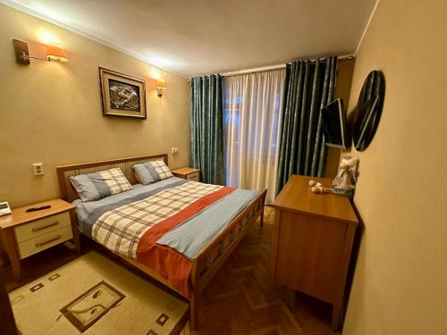 a bedroom with a bed and a desk with a television at 29 Nest Residence in Craiova
