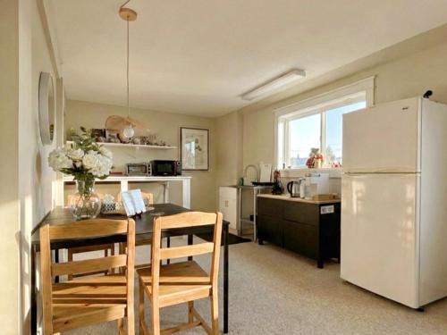 a kitchen with a table and a white refrigerator at Horizon Suite-Baylight in Malahat